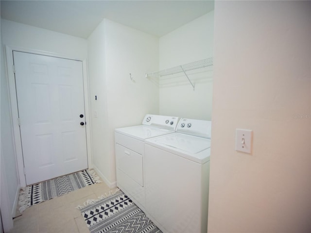 laundry room with light tile patterned floors, washer and clothes dryer, laundry area, and baseboards