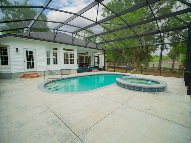 view of swimming pool with a lanai, entry steps, a patio area, and a pool with connected hot tub