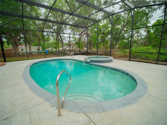 view of swimming pool with a pool with connected hot tub, a patio, and glass enclosure