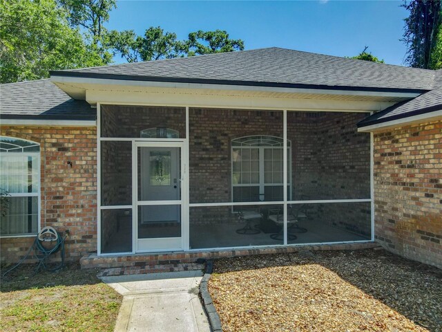 exterior space with brick siding and a shingled roof