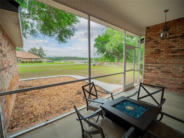 unfurnished sunroom featuring an outdoor fire pit