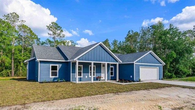 10055 Fox Hollow Dr, Hampton, FL 32044 - view of front of house with a porch, a garage, board and batten siding, concrete driveway, and a front lawn
