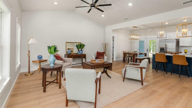 10055 Fox Hollow Dr, Hampton, FL 32044 - living room featuring visible vents, light wood-style flooring, lofted ceiling, and ceiling fan with notable chandelier