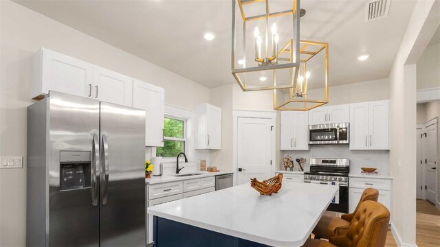 10055 Fox Hollow Dr, Hampton, FL 32044 - kitchen with a kitchen island, a sink, stainless steel appliances, decorative backsplash, and a notable chandelier