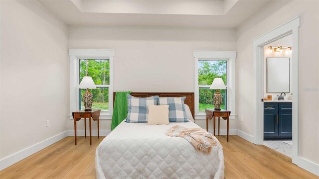 10055 Fox Hollow Dr, Hampton, FL 32044 - bedroom with light wood-style floors, a sink, baseboards, and connected bathroom