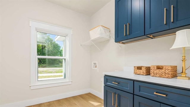 10055 Fox Hollow Dr, Hampton, FL 32044 - clothes washing area with light wood-style floors, baseboards, washer hookup, and cabinet space