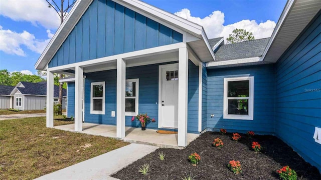 10055 Fox Hollow Dr, Hampton, FL 32044 - property entrance featuring board and batten siding, covered porch, and a lawn