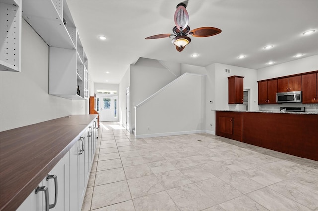 6382 SW 48th Dr, Gainesville, FL 32608 - kitchen with stainless steel microwave, a ceiling fan, recessed lighting, and dark stone counters
