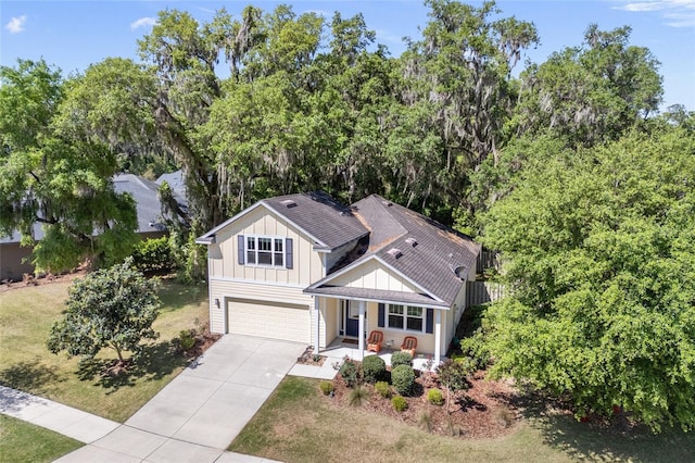 6382 SW 48th Dr, Gainesville, FL 32608 - view of front of house featuring board and batten siding, an attached garage, concrete driveway, a porch, and a front lawn