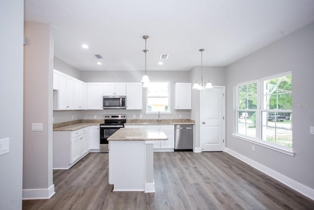 kitchen with a sink, baseboards, a healthy amount of sunlight, and stainless steel appliances