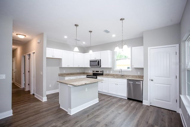 kitchen featuring white cabinetry, a kitchen island, dark wood-type flooring, visible vents, and appliances with stainless steel finishes