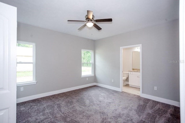 unfurnished bedroom featuring baseboards, multiple windows, and light colored carpet