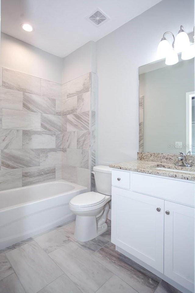 bathroom with a notable chandelier, vanity, toilet, visible vents, and bathtub / shower combination