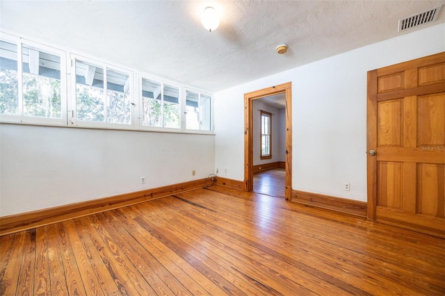 562 NE 2nd Ave, Gainesville, FL 32601 - empty room with light wood-style flooring, a smoke detector, and a textured ceiling