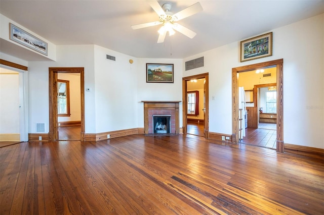 562 NE 2nd Ave, Gainesville, FL 32601 - unfurnished living room featuring hardwood / wood-style floors, a tiled fireplace, and a ceiling fan