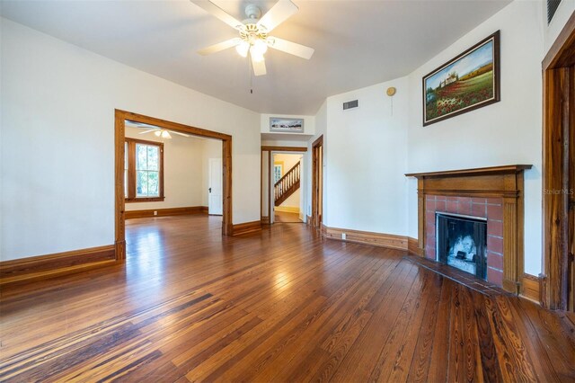 562 NE 2nd Ave, Gainesville, FL 32601 - unfurnished living room featuring a tile fireplace, hardwood / wood-style flooring, ceiling fan, and stairs