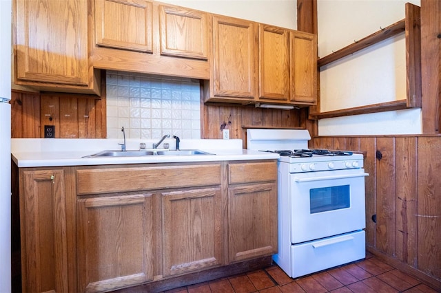 562 NE 2nd Ave, Gainesville, FL 32601 - kitchen featuring white gas range, decorative backsplash, wood walls, light countertops, and wainscoting