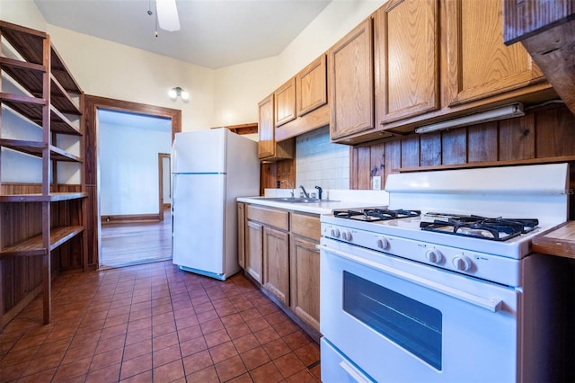 562 NE 2nd Ave, Gainesville, FL 32601 - kitchen with white appliances, tasteful backsplash, light countertops, a ceiling fan, and dark tile patterned flooring