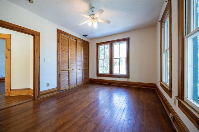 562 NE 2nd Ave, Gainesville, FL 32601 - unfurnished bedroom featuring wood-type flooring, multiple windows, a closet, and ceiling fan
