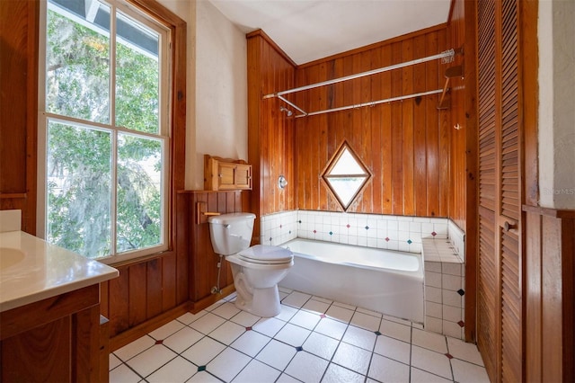 562 NE 2nd Ave, Gainesville, FL 32601 - full bath featuring a bathtub, plenty of natural light, vanity, wood walls, and tile patterned flooring