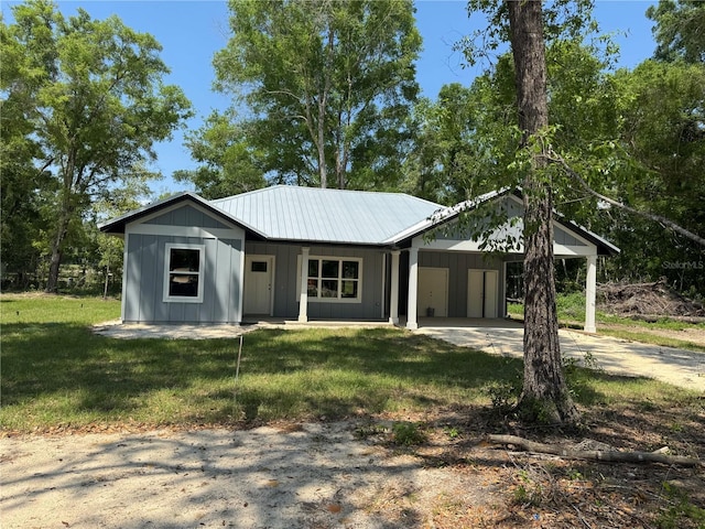 view of front of house with board and batten siding, driveway, a front yard, and a carport