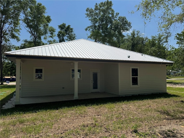 back of house with a yard and metal roof