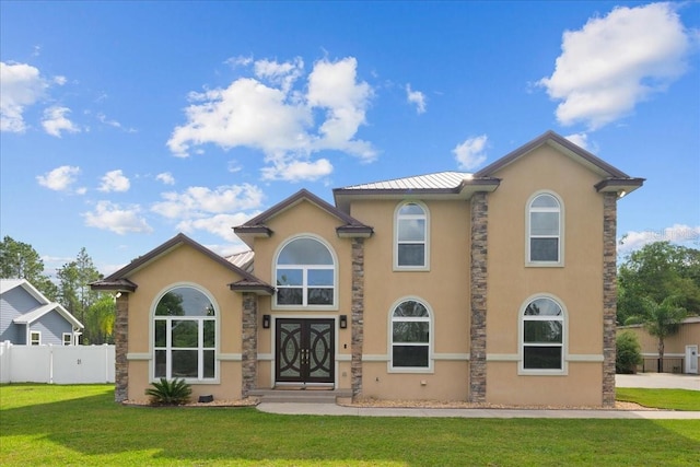 9835 SW 80th Pl, Hampton, FL 32044 - mediterranean / spanish-style house with stone siding, stucco siding, fence, and a front yard