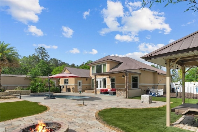 9835 SW 80th Pl, Hampton, FL 32044 - rear view of house featuring an outdoor fire pit, metal roof, a lawn, fence, and a patio