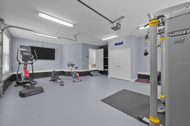 9835 SW 80th Pl, Hampton, FL 32044 - exercise area featuring a textured ceiling, a garage, and baseboards