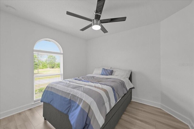 9835 SW 80th Pl, Hampton, FL 32044 - bedroom with a ceiling fan, wood finished floors, baseboards, and multiple windows
