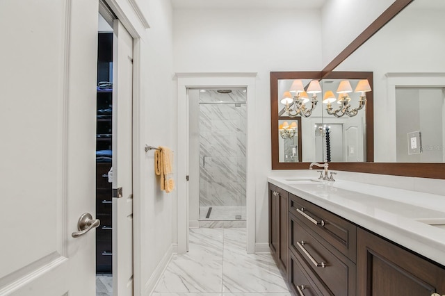 full bath with a shower stall, marble finish floor, vanity, baseboards, and a notable chandelier