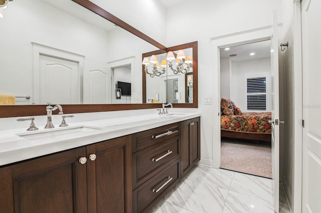 bathroom featuring a notable chandelier, double vanity, a sink, and ensuite bathroom