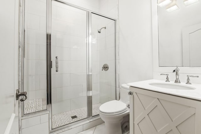 bathroom featuring a stall shower, toilet, and vanity