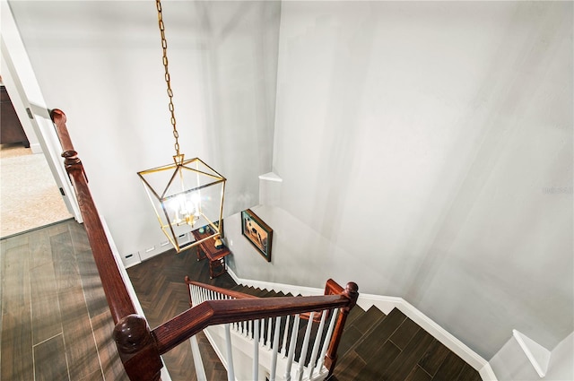stairs with a notable chandelier and baseboards