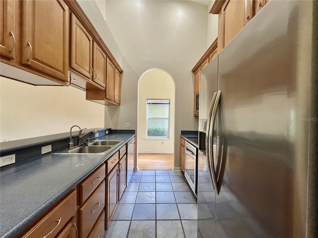 11795 Creek Dr, Alachua, FL 32615 - kitchen featuring stainless steel appliances, brown cabinetry, a sink, and dark countertops