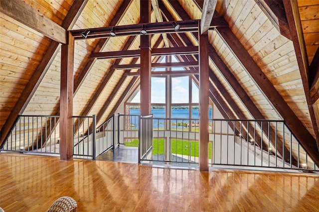 additional living space featuring a water view, wood-type flooring, wood ceiling, and vaulted ceiling with beams