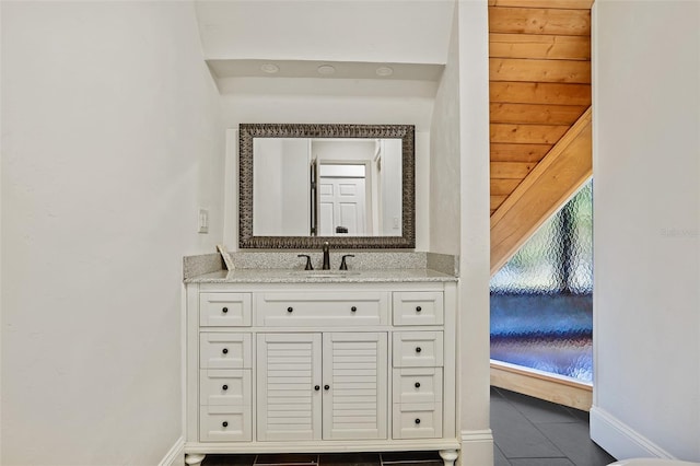 bathroom featuring vanity, baseboards, and tile patterned flooring