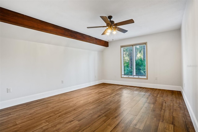 spare room featuring wood finished floors, ceiling fan, baseboards, and vaulted ceiling with beams