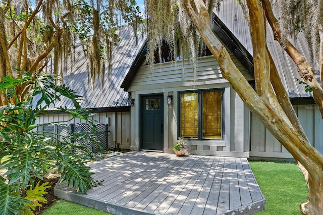 exterior space featuring fence, metal roof, and a deck
