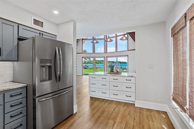 kitchen featuring light wood-style floors, visible vents, gray cabinets, and stainless steel fridge