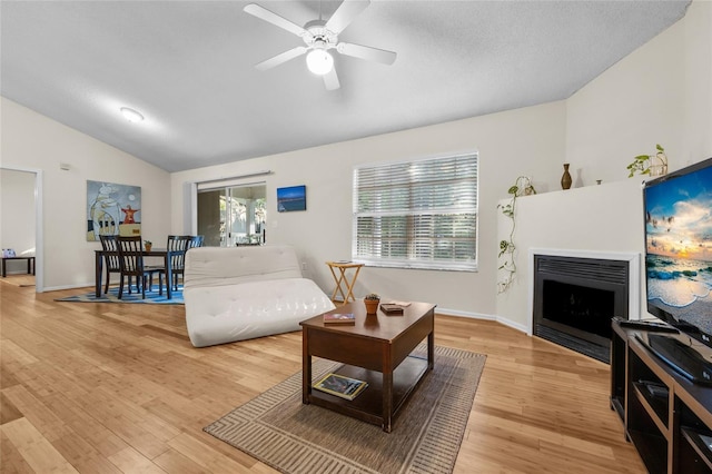 10000 SW 52nd Ave Unit 77, Gainesville, FL 32608 - living area featuring ceiling fan, a fireplace, light wood-type flooring, lofted ceiling, and baseboards