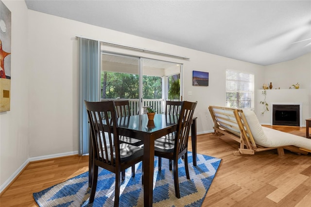10000 SW 52nd Ave Unit 77, Gainesville, FL 32608 - dining space with baseboards, light wood-type flooring, and a fireplace