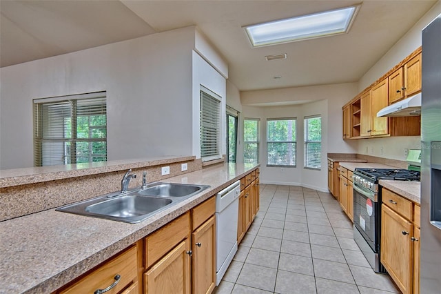 1983 SW 65th Dr, Gainesville, FL 32607 - kitchen with stainless steel gas stove, under cabinet range hood, dishwasher, light tile patterned floors, and light countertops