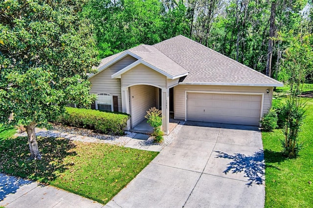 1983 SW 65th Dr, Gainesville, FL 32607 - view of front of property with an attached garage, driveway, a shingled roof, and a front lawn