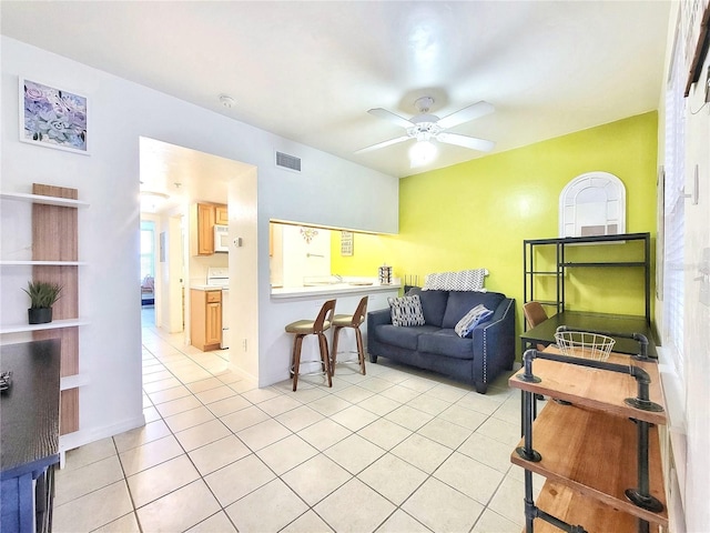 living room with baseboards, a ceiling fan, light tile patterned flooring, and visible vents