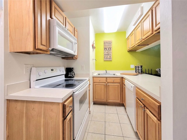 kitchen featuring light countertops, white appliances, a sink, and light tile patterned floors