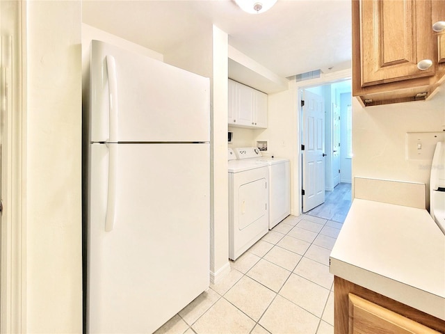 laundry area with light tile patterned flooring, cabinet space, washing machine and dryer, baseboards, and visible vents