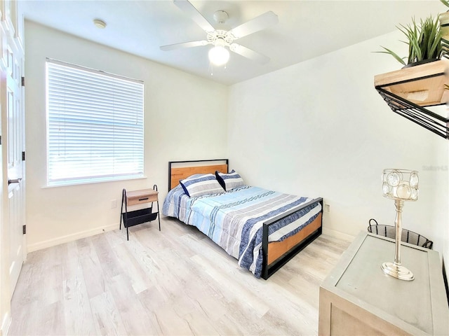 bedroom featuring baseboards, a ceiling fan, and light wood-style floors