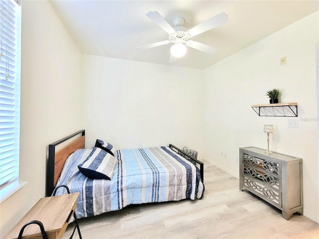 bedroom with light wood-style flooring, baseboards, and ceiling fan