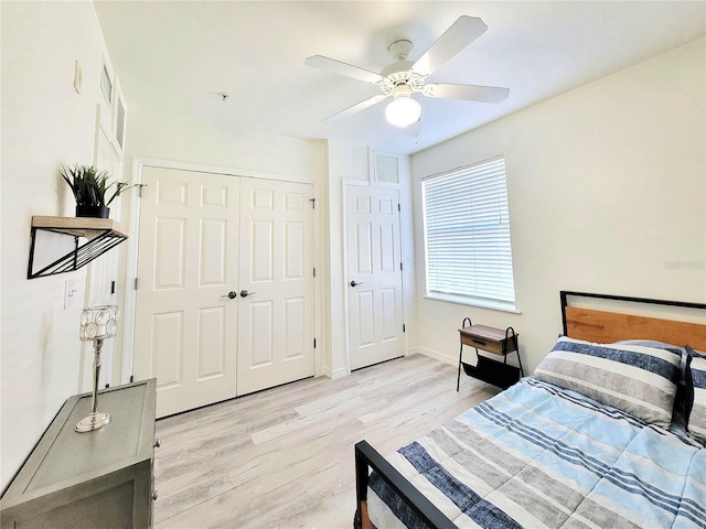 bedroom with a closet, light wood-type flooring, ceiling fan, baseboards, and visible vents